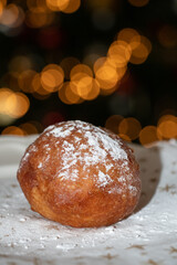 Oliebol fresh Dutch pastry on plate festive tissue with Christmas tree background. New years treat in the Netherlands. Happy New Year snack.