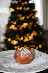 Oliebol fresh Dutch pastry on plate festive tissue with Christmas tree background. New years treat...