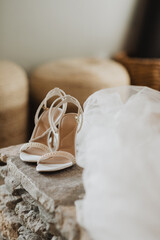 Elegant White Bridal Heels with Pearl Embellishments on Rustic Stone Surface, Capturing Wedding Day Details with Soft Romantic Backdrop