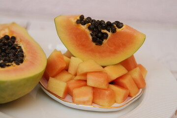 Papaya slices on the white plate on the white background