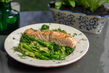 Pan fried salmon with warm green spring salad, fresh and healthy lunch, close up