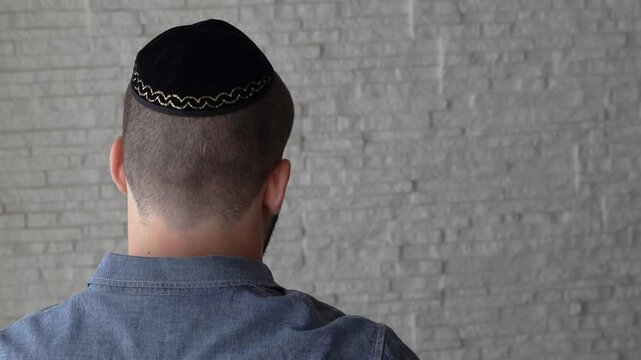 young jewish man with yarmulke praying 