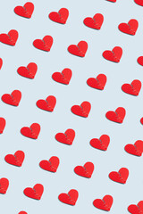 Red paper craft torn heart pattern on pastel blue background, vertical wallpaper. Creative Valentine's Day poster idea with broken heart