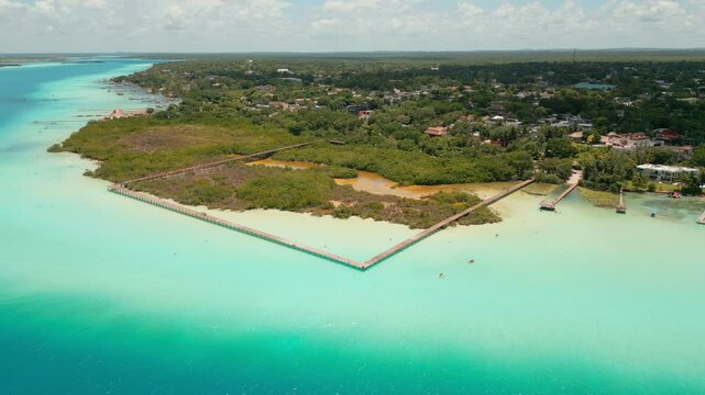Toma a&eacute;rea de dron del Parque Ecol&oacute;gico de Bacalar, su laguna color turquesa, su muelle de madera y sus manglares.