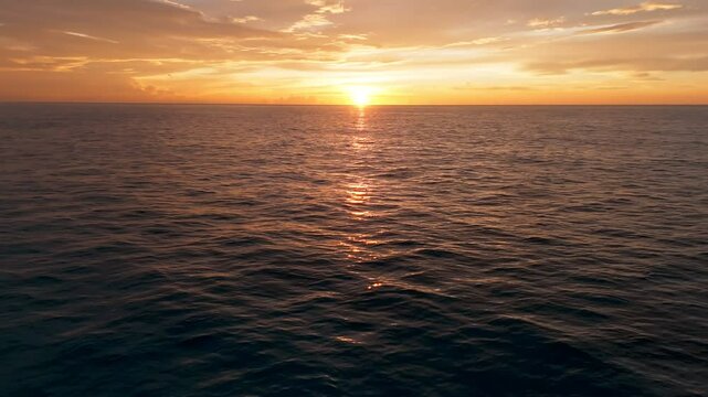 Toma a&eacute;rea de dron volando sobre un calmado mar, descubriendo de un &eacute;pico, hermoso y dorado amanecer en las playas de Canc&uacute;n
