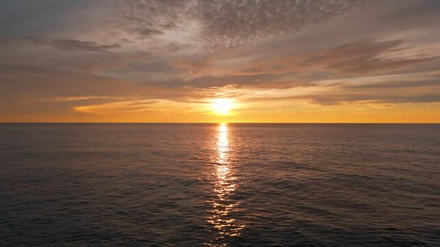 Toma a&eacute;rea de dron de la silueta de pareja enamorada parada sobre un rompeolas en un &eacute;pico, pac&iacute;fico, c&aacute;lido, dorado y rom&aacute;ntico amanecer en el mar de Canc&uacute;n.