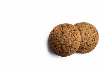Two round oatmeal cookies resting on a clean white background, highlighting their golden texture and homemade charm. Perfect for bakery promotions, food photography, conveying cozy, sweet simplicity