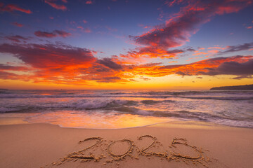 Happy New Year 2025 concept, lettering on the beach. Written text on the sea beach at sunrise.