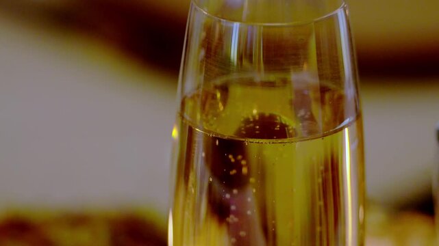 plan fixe sur une coupe de champagne, une soir&eacute;e de f&ecirc;te avec des amis, zoom arri&egrave;re sur la coupe de champagne pour laisser apparaitre les flamme de bougies