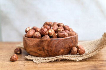 Raw hazelnuts in a wooden bowl