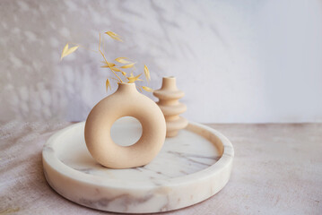 Modern beige ceramic small vases in marble tray  . Scandinavian interior style 