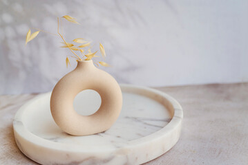 Modern beige ceramic small vases in marble tray  . Scandinavian interior style 