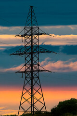 transmission line support against a beautiful bright sunset. vertical shot