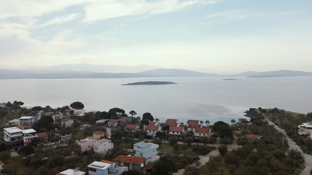 Calm aegean sea beach and coastal houses of sakran town of turkey, aerial view