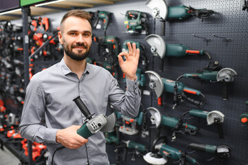 a buyer in a hardware store walks between with a power tool