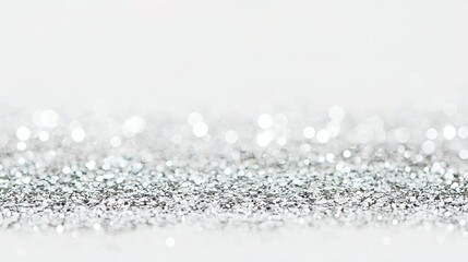Fototapeta premium A close-up of a white background with silver glitter on it, appearing both at the bottom of the image