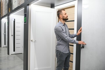 Buyer chooses door in store. Shop window of doors. A large selection of doors for house