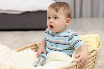 Little baby with money in bottle at home