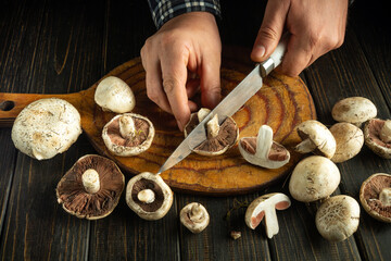 Hands skillfully cut vibrant mushrooms on a wooden board, surrounded by earthy tones. The atmosphere is cozy, evoking a sense of culinary creativity and seasonal freshness