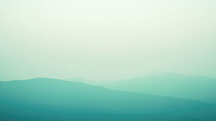 Fototapeta premium Serene misty green hills under a pale sky