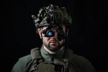 A special force soldier using modern night vision and thermal imaging in the darkness. Close up.