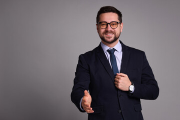 Portrait of banker in glasses on grey background, space for text