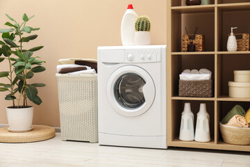 Wicker basket full of laundry, washing machine and detergent in bathroom