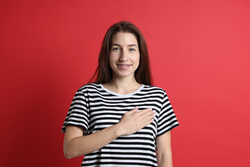 Fototapeta premium Woman making promise on red background. Oath gesture