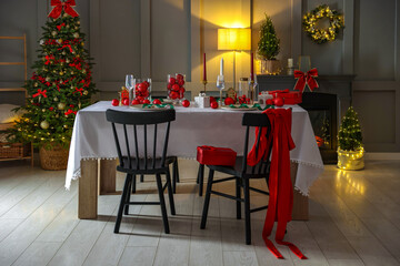 Christmas celebration. Festive table setting with dishware, glasses and decor
