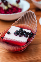 Close Up of Creamy White Pudding with Berries and Red Syrup