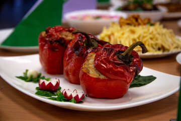 Stuffed Red Bell Peppers with Herb Garnish on White Plate