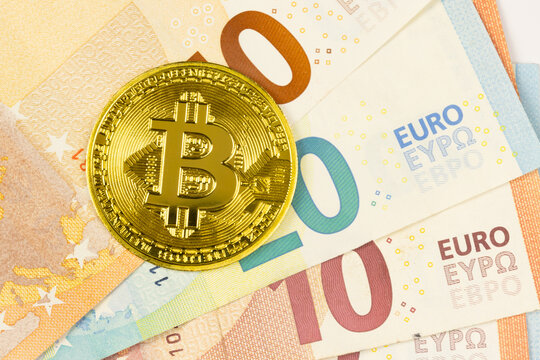 cryptomonnaie, une pi&egrave;ce repr&eacute;sentant le Bitcoin sur plusieurs billets d'euros, en gros plan