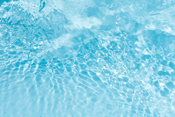 Blue water with ripples on the surface. Defocus blurred transparent blue colored clear calm water surface texture with splashes and bubbles. Water waves with shining pattern texture background.
