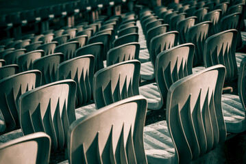 Sector at stadium arena, rows of plastic gray seats of amphitheater, cloudy day