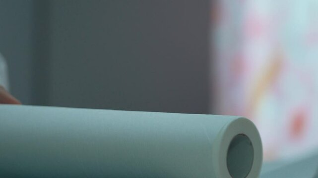 Close-up video of a healthcare professional laying out a napkin on an examination table before examining a patient. Suitable for hygiene, cleanliness, health themes.