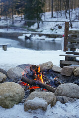 Burning fire bonfire in winter snowy day close up.