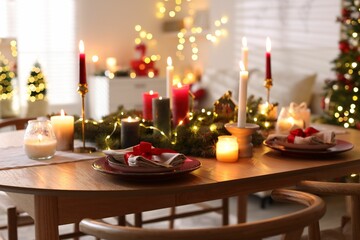Festive table setting in room decorated for Christmas, closeup. Bokeh effect