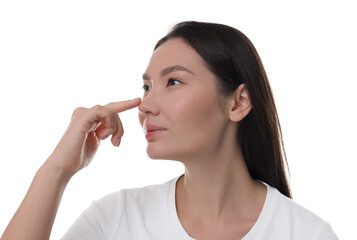 Young woman touching her nose on white background