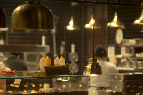 A vibrant kitchen bustling with skilled chefs expertly preparing delicious food, complete with various condiments and essential kitchen equipment