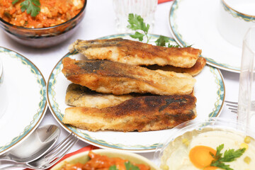 Fried Christmas carp on a festive table. Traditional Polish Christmas Eve dish served on an elegant holiday table. Culinary tradition in Eastern Europe. Elegant table setting.