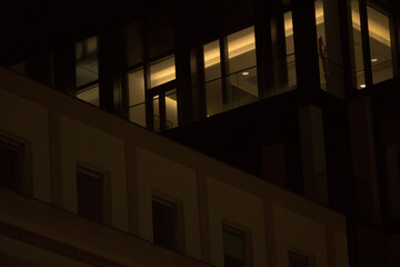 Fototapeta premium At night, the building with numerous windows becomes fully illuminated, creating a stunning visual effect against the dark sky