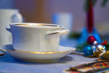 Christmas Eve decoration with festive tea set and seasonal ornaments on a cozy table