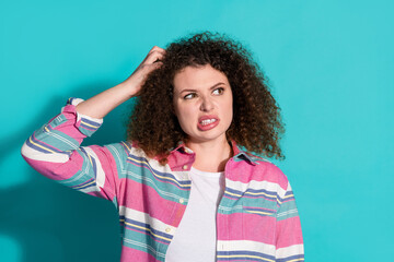 Portrait of nice young woman scratch head look empty space wear shirt isolated on turquoise color...