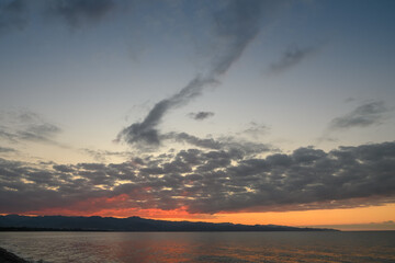 Breathtaking sunset over tranquil waters with dramatic clouds reflecting vibrant colors