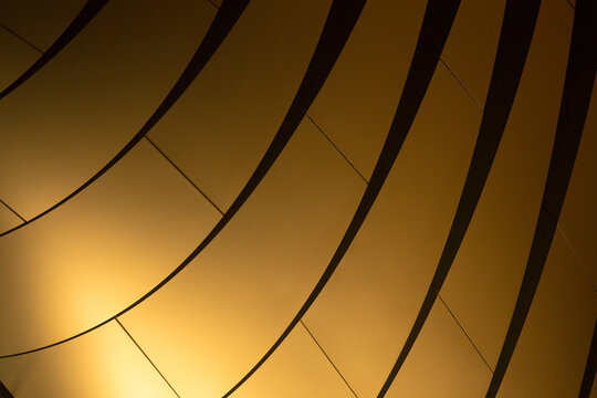 The design features striking abstract patterns composed of golden lines and curves, enhancing the aesthetic appeal of architectural forms