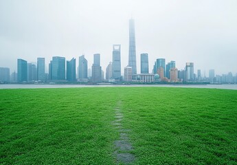 Fototapeta premium Beautiful green lawn with a city skyline in the background, a white sky, clear daylight, a grass field with a path leading to tall buildings. The Lujiazui business district of Shanghai, China.