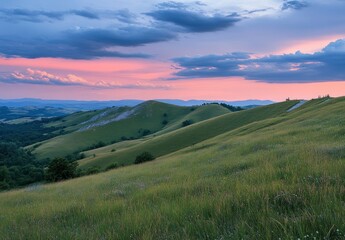 Fototapeta premium Beautiful summer landscape with green grass on the mountain hill and a sunset sky. The image is colorful, capturing the summer mood with sun rays, highly detailed, and in sharp focus. The scene 