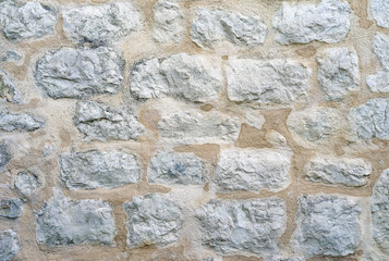 Stone wall rustic background, various sizes and colors of natural stones texture