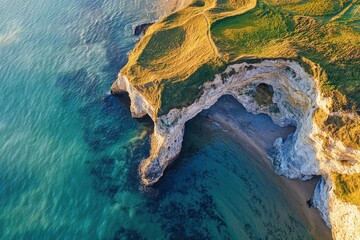 Dorset, United Kingdom. The iconic Dunnington arch at the coastline of cozy beach in landscape with blue sky and green grass on cliff top. Aerial view from above of beautiful nature scenery with rock