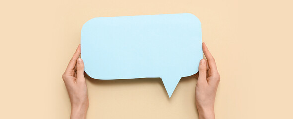 Female hands with blank paper speech bubble on color background, closeup